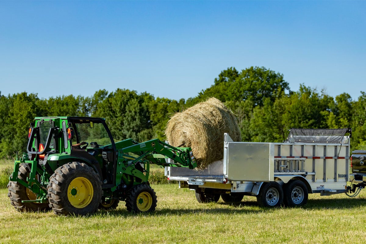 Tractor Loading A Barrel Of Hay In Mission Commercial Utility Dump Trailer