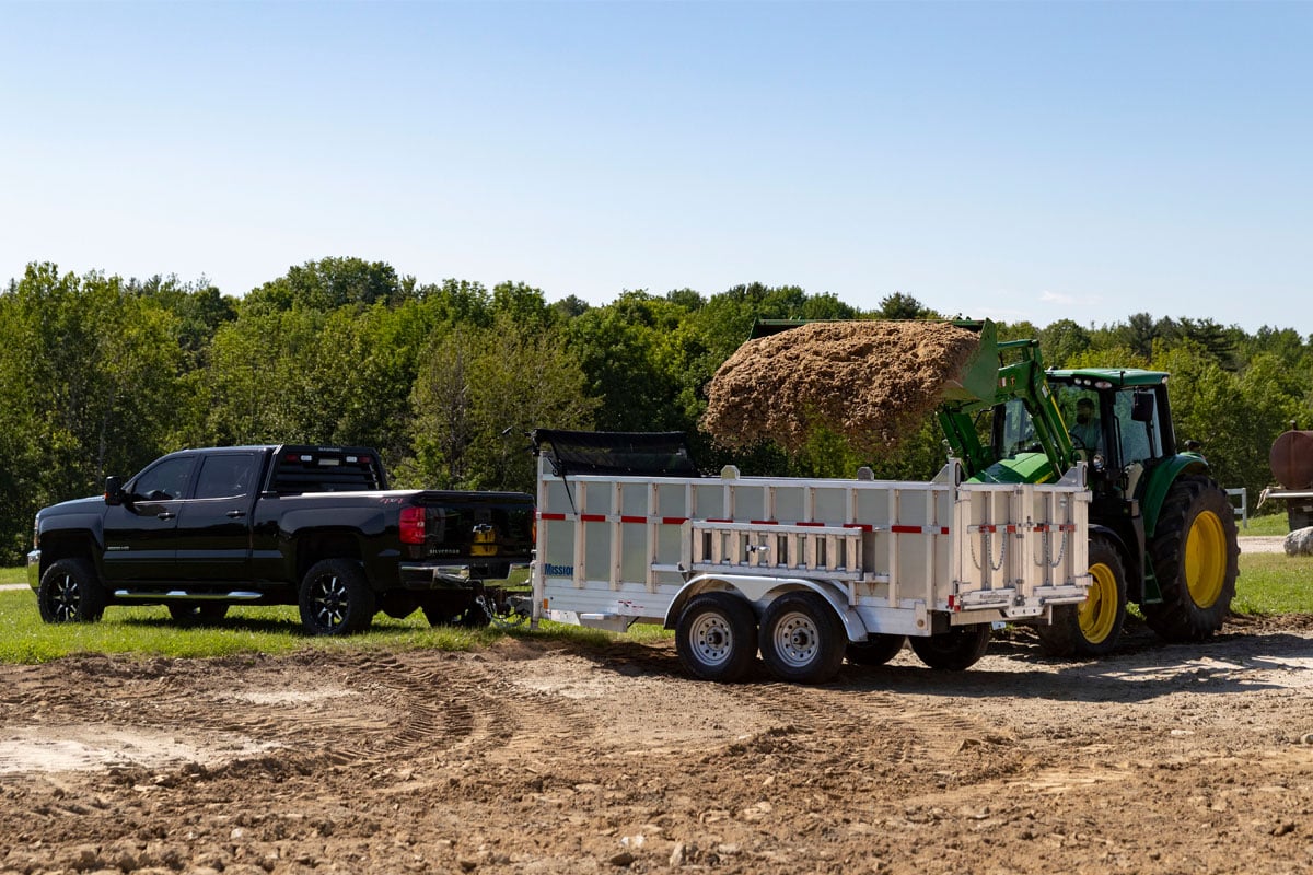 Tractor Loading Dirt In Mission Commercial Utility Dump Trailer